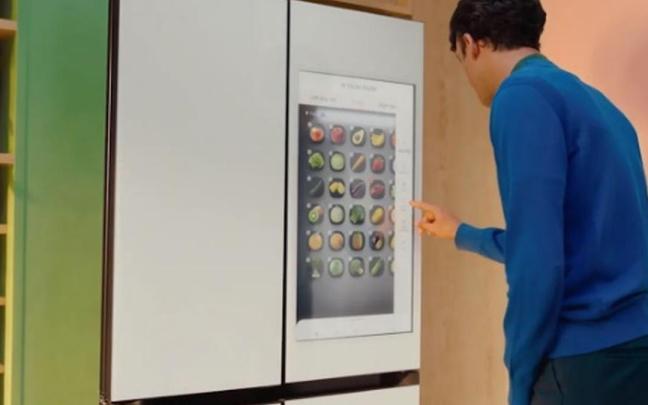 Un hombre maneja la pantalla táctil de un frigorífico con IA. / Samsung Un hombre maneja la pantalla táctil de un frigorífico con IA.