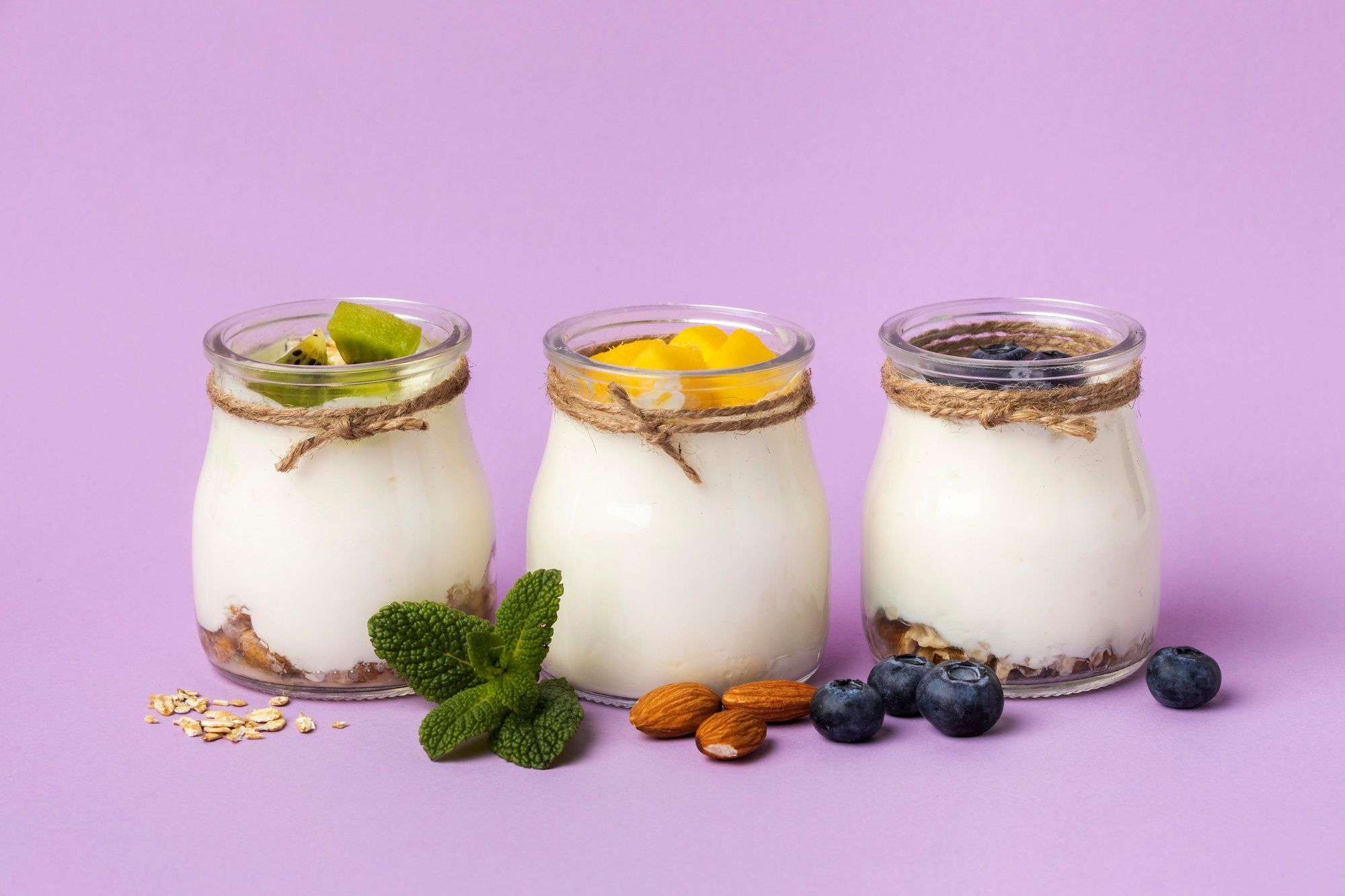 Tres yogures griegos con frutas y frutos secos.