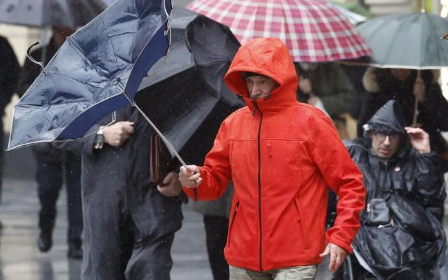 hombre trata de protegerse de la lluvia y el viento este jueves en Bilbao. / Miguel Toña hombre trata de protegerse de la lluvia y el viento este jueves en Bilbao.